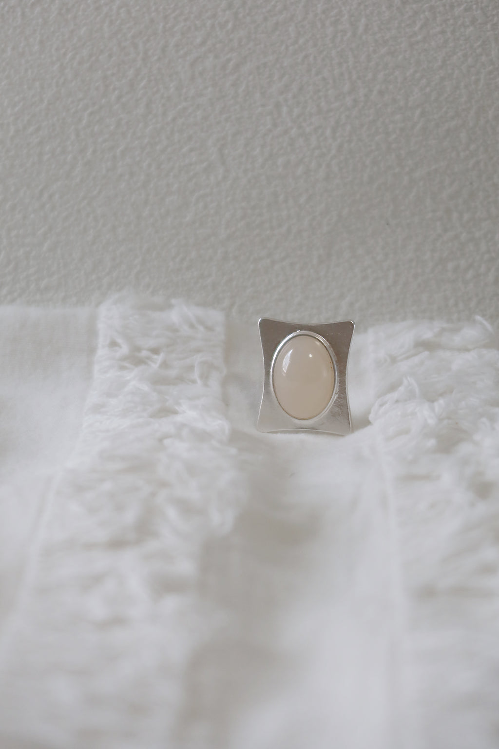 Silver Ring on a white textured surface