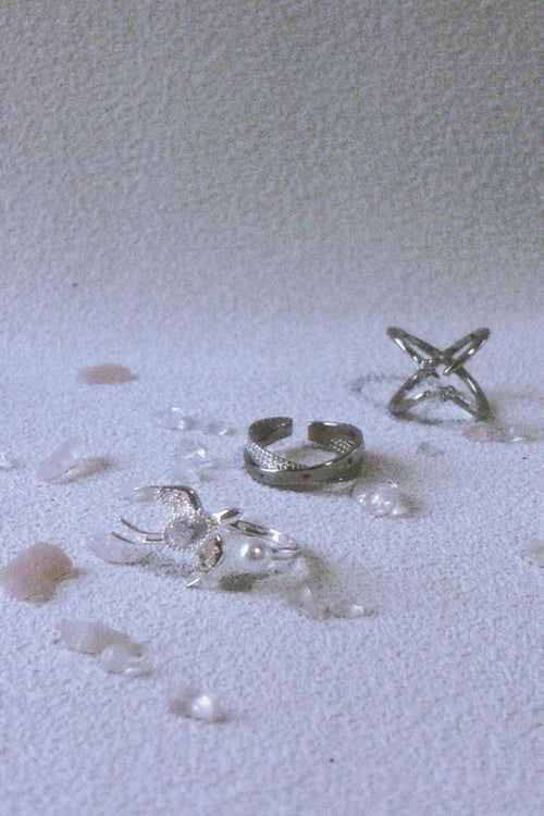 Silver rings on a textured white surface