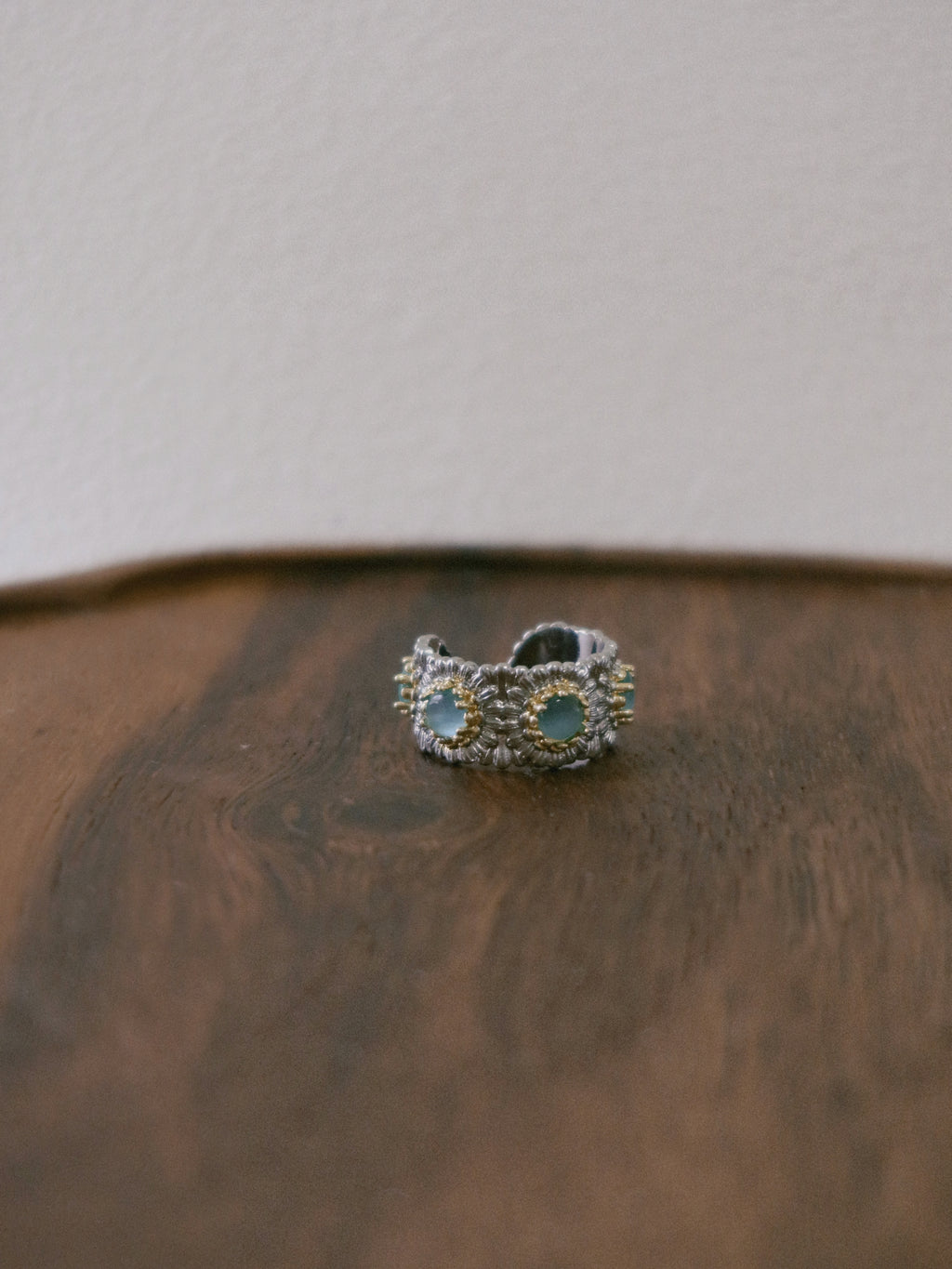 Silver ring with turquoise stones on a wooden surface