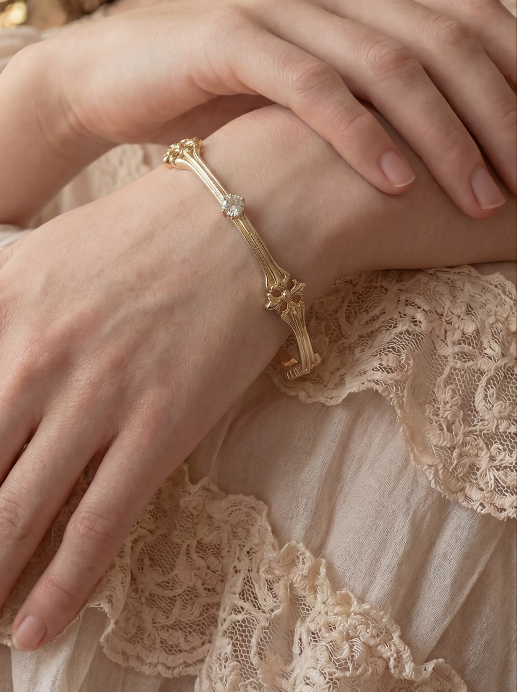 Close-up of a person wearing a gold bracelet with a blurred background