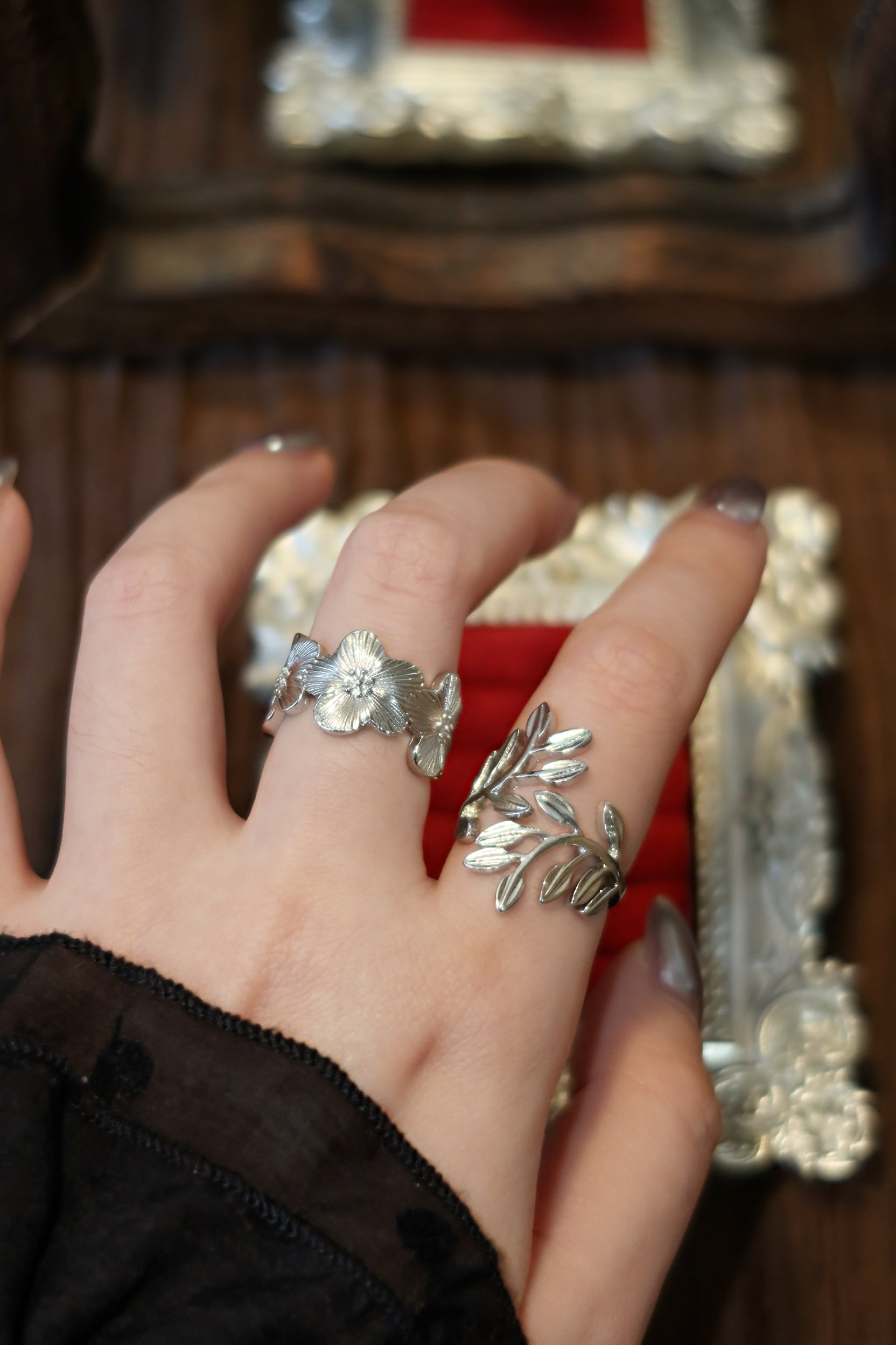 Laurel leaf ring stacked with floral silver ring on hand