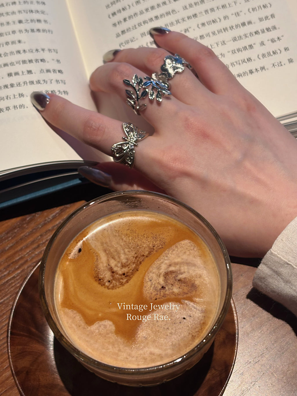 Laurel leaf ring worn with butterfly ring, close-up view