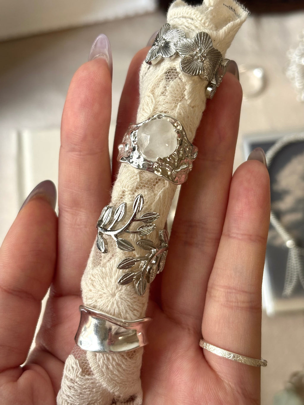 Laurel leaf ring stacked with floral, moonstone, and cuff rings