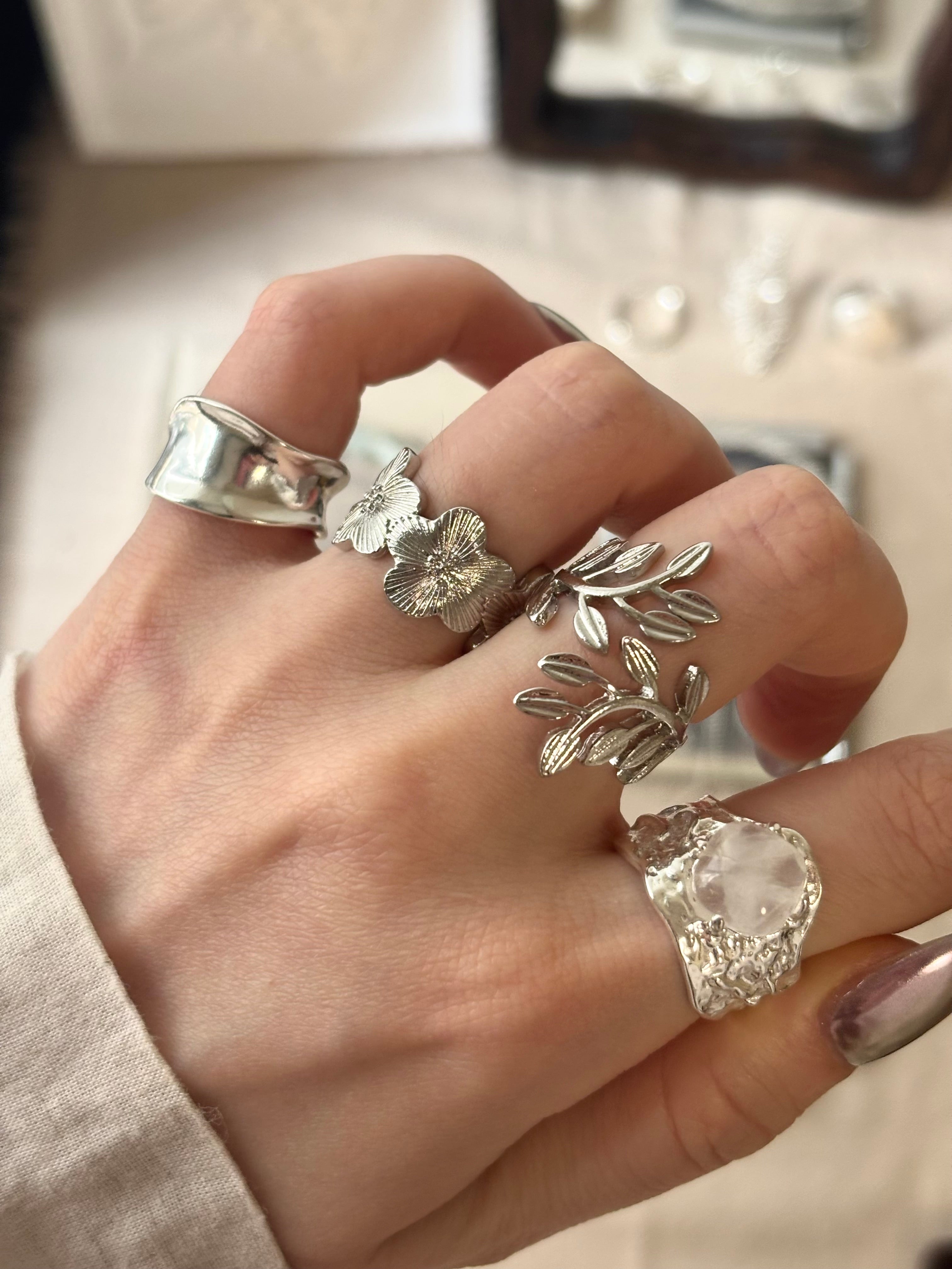 Laurel leaf ring worn on hand, stacked with floral and cuff rings